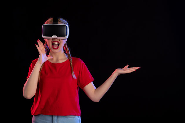 游戏年轻女性在黑暗的墙上玩虚拟现实的正面图视图正面年轻女性