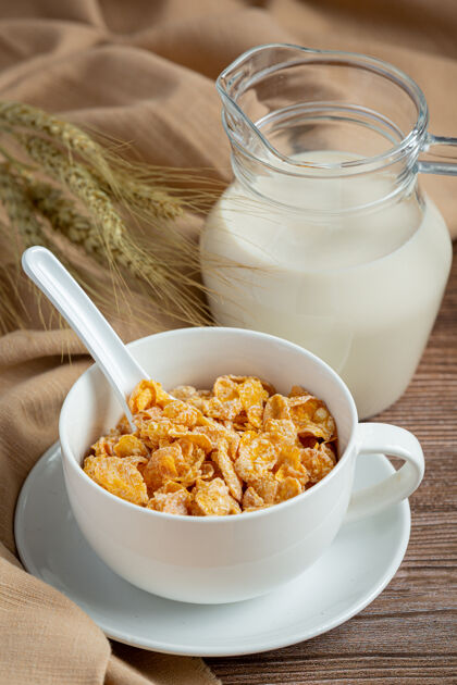 纤维碗里的麦片和牛奶放在深色的木制背景上薄片膳食房子