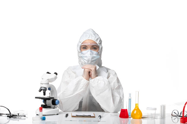 套装正面图年轻女医生穿着防护服 带口罩因冠状病毒呈浅白色背景疾病健康大流行冠状病毒药品疾病实验室