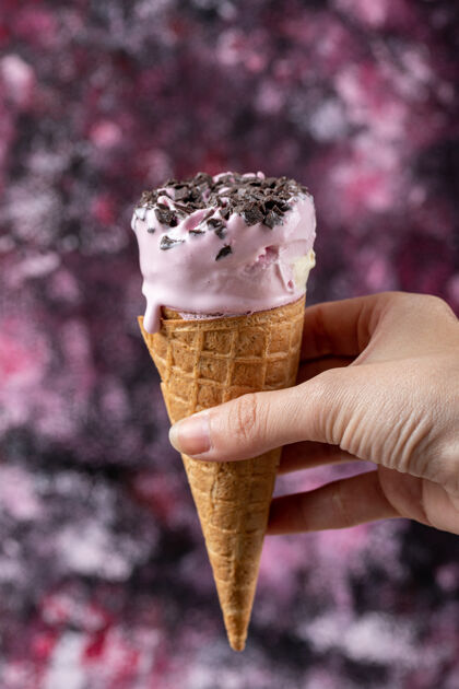 脆手里拿着一个华夫饼筒里的蓝莓冰淇淋面粉美味奶油