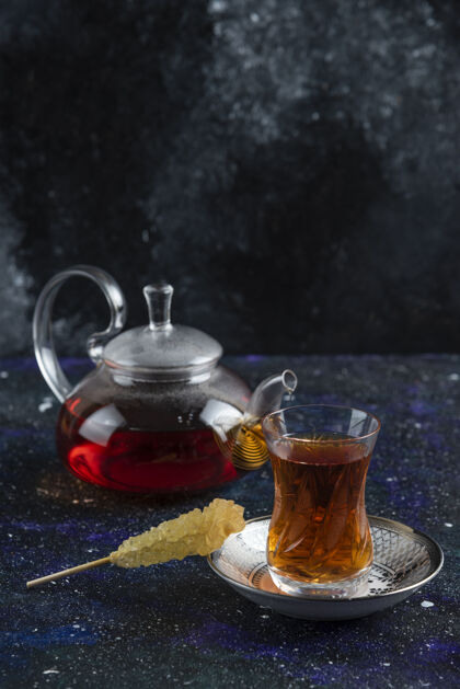 勺子垂直的茶壶和一杯茶壶玫瑰草药