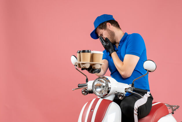 坐着正面图男性信使坐在自行车上拿着咖啡杯在粉红色咖啡拿着快餐
