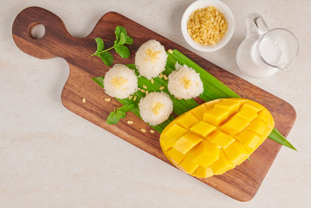 甜点成熟的芒果和糯米与椰子奶放在石头表面的木板上 热带水果甜点水果夏季泰国甜点美味椰子奶糖