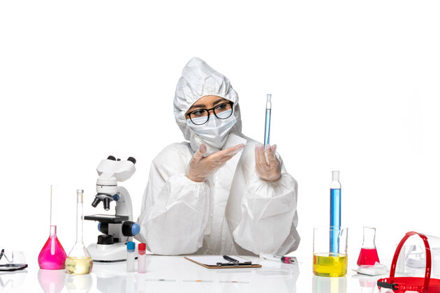 保温瓶正面图身穿特殊防护服的年轻女化学家拿着浅白色背景上蓝色溶液的烧瓶 科维化学病毒实验室化学实验室外套溶液