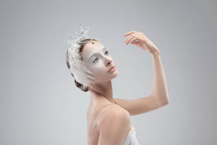 运动白色工作室背景上年轻优雅的芭蕾舞演员的特写镜头年轻动作天鹅