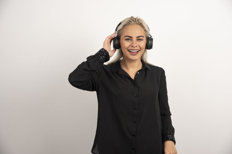 女孩戴着耳机在白色背景上听歌曲的女人高质量的照片女人成人女人