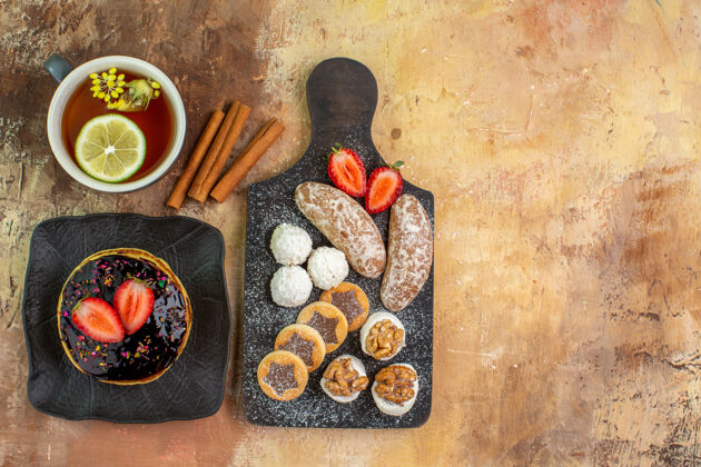 食物顶视图美味的甜煎饼与茶和糖果放在灯桌上美味早餐顶部