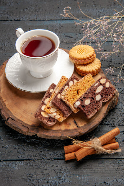 杯子在黑暗的桌子上可以看到一杯茶 里面放着饼干和蛋糕蛋糕餐仪式