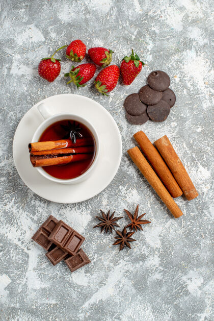 桌子俯瞰桂皮茴香籽茶和一些草莓巧克力桂皮茴香籽在桌子的左侧美味壁板杯子