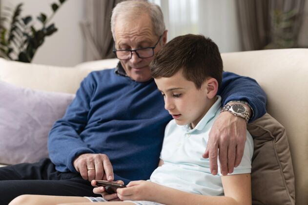 室内孙子和爷爷在沙发上放松世代在家沙发