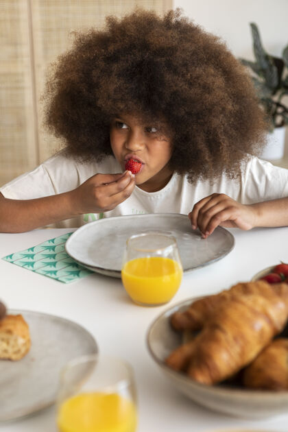 盘子卷发小女孩在吃早餐垂直家庭里面