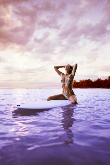 冲浪一个穿着比基尼的女人用蒸汽的方式冲浪比基尼海洋水