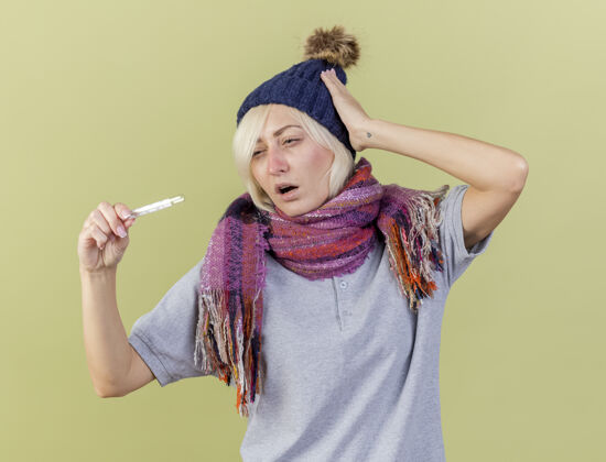 金发年轻的金发病斯拉夫女人戴着冬天的帽子和围巾把手放在头上女人斯拉夫围巾