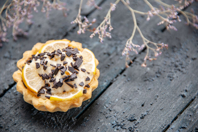 甜点黑桌子上的柠檬馅饼配巧克力干花枝水果树枝面包房