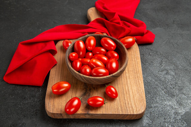 食物底部视图碗与樱桃番茄和红毛巾在砧板上黑暗的背景深色有机背景