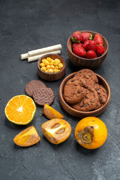 可食用水果前视图新鲜的红色草莓和饼干在黑暗的背景柑橘水果健康