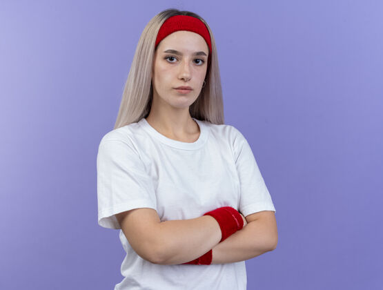 头带自信的年轻白人运动女孩戴着背带和头带运动背带站立