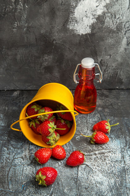 容器前视图新鲜草莓在篮子里黑暗的地板上健康深色新鲜草莓
