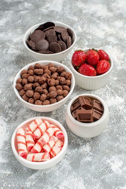 碗底视图碗 灰白色背景上有白色 红色糖果 草莓 巧克力 谷类食品和可可新鲜地面浆果