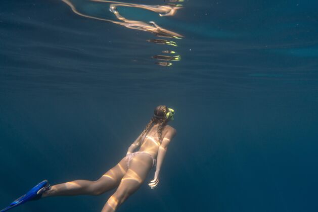 水下戴着潜水器在海里游泳的女人海洋水肺潜水女子