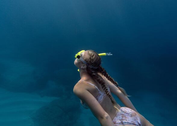 水平戴着潜水器在海里游泳的女人游泳水肺潜水海洋