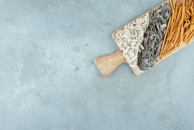 美味一个木制砧板充满了葵花籽和面包棒高品质的照片好吃好吃木板