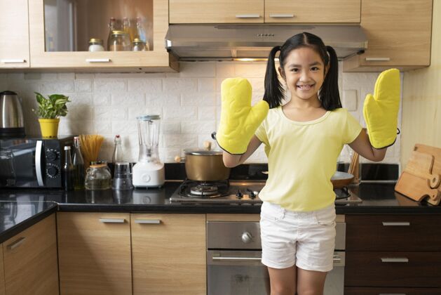 女孩戴着厨房手套的中枪女孩中镜头孩子室内