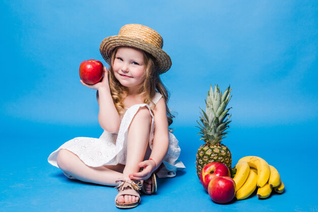 小女孩小女孩在蓝色的墙上玩水果孩子可爱可爱