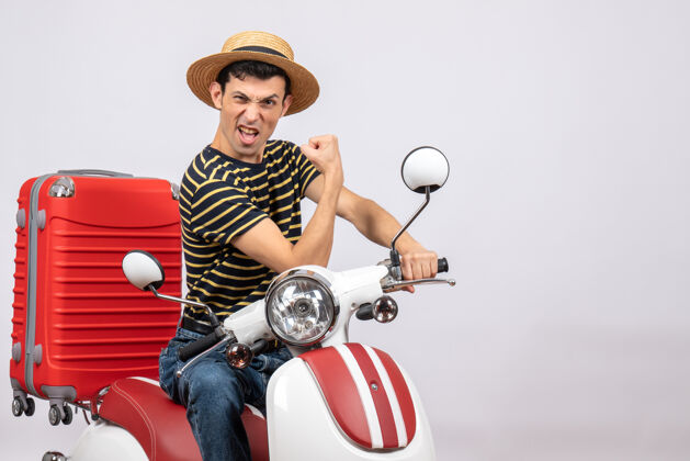 手臂前视图自信的年轻人与草帽轻便摩托车显示手臂肌肉男人自信的年轻人帽子