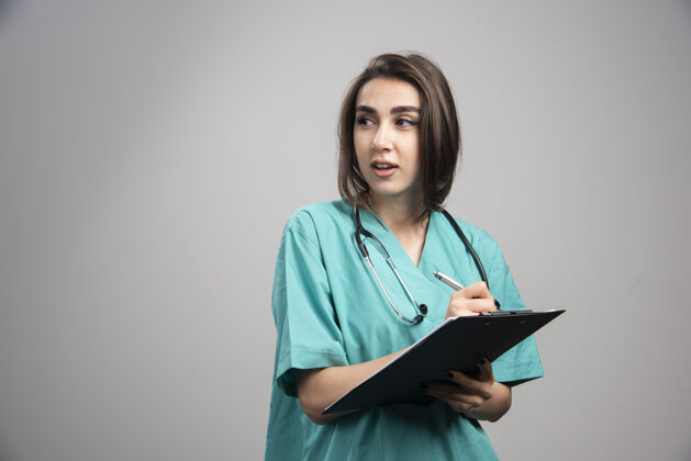 医疗女医生用听诊器写在剪贴板上高质量的照片女性治疗工作