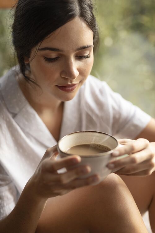 女人拿着咖啡杯的女人咖啡杯享受放松