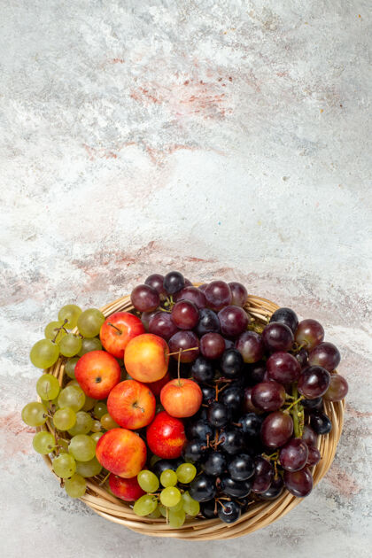 水果白色表面有李子的新鲜葡萄俯视图健康成熟新鲜葡萄