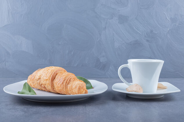 健康早餐一杯卡布奇诺和羊角面包 灰色背景桌子面包房美味