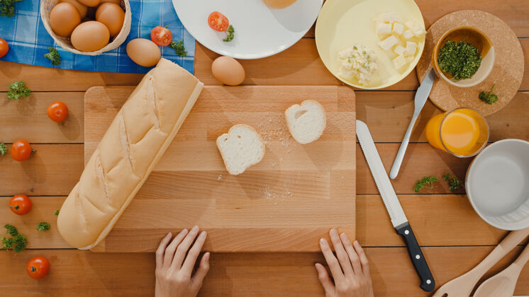 酵母年轻的亚洲女厨师手拿刀在木板上切全麦面包健康有机三明治