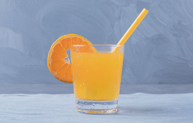 玻璃杯在灰色背景上拍摄新鲜橙汁的特写照片五餐桌单人
