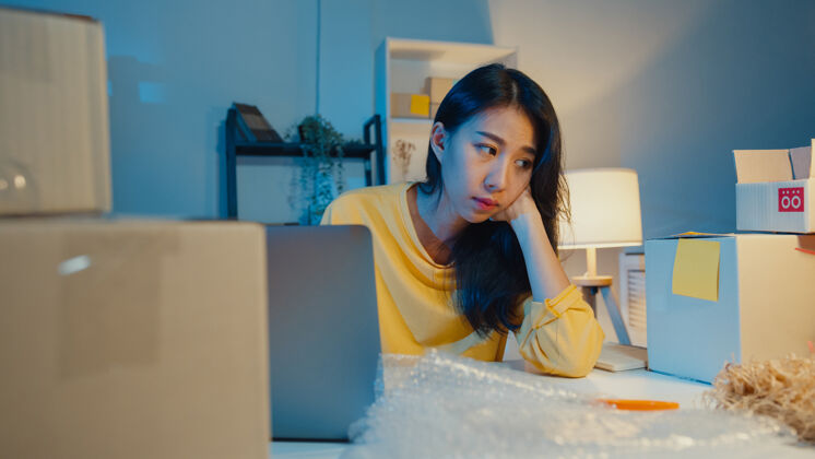 加班年轻的亚洲女商人晚上在家办公时因销售不佳而感到紧张和不安夜晚疲惫初创企业