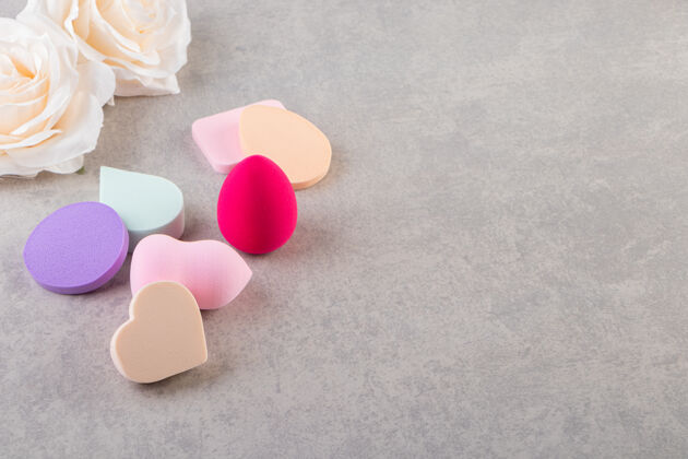 粉色五颜六色的化妆海绵放在石头桌上蓝色化妆化妆