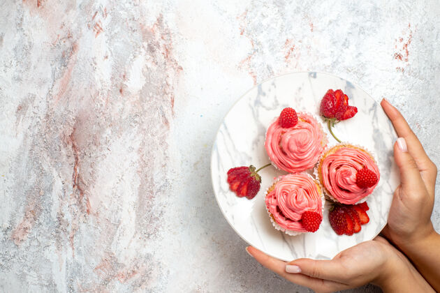 糖白色表面上有新鲜的红色草莓的粉色草莓蛋糕俯视图饼干奶油草莓