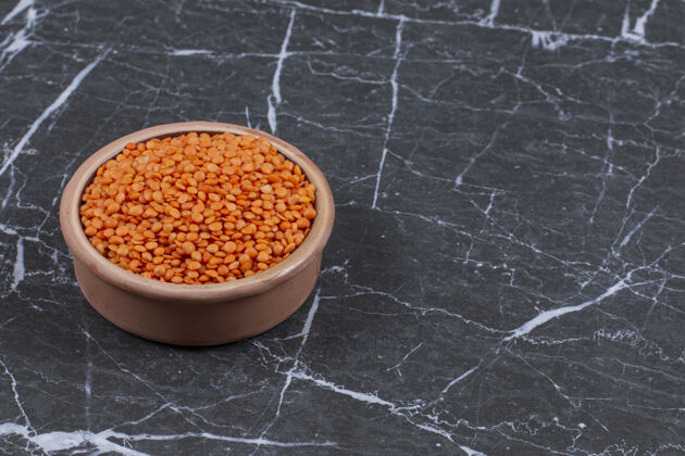 等级新鲜的生扁豆放在陶碗里 放在黑石上健康农业益处