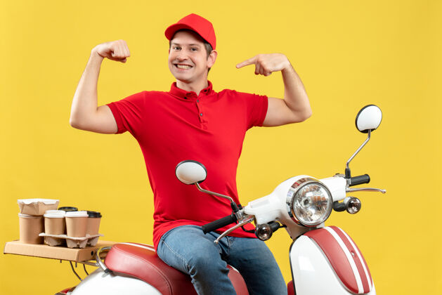 人顶视图自豪的年轻人穿着红色衬衫和帽子 在黄色背景下传递命令摩托车男人背景