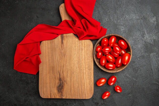 深色顶视图碗与樱桃番茄红毛巾砧板和樱桃番茄在黑暗的背景棋盘食物番茄