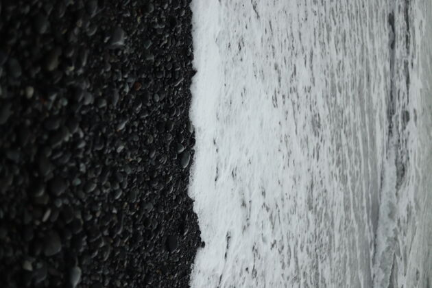 灰度一个垂直的灰度拍摄的海滩上的波浪上来的海岸海洋白色海岸