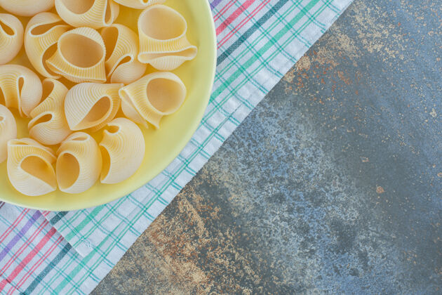 碗把意大利面放在碗里 毛巾放在大理石背景上美味美味菜肴