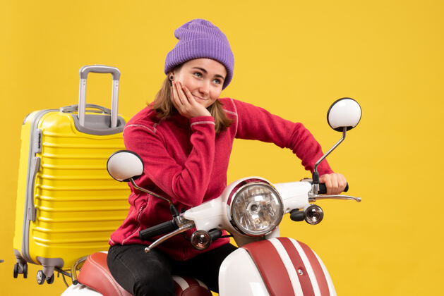 满意的小女孩前视图满意的年轻女孩骑着轻便摩托车 手放在下巴上正面脚踏车下巴