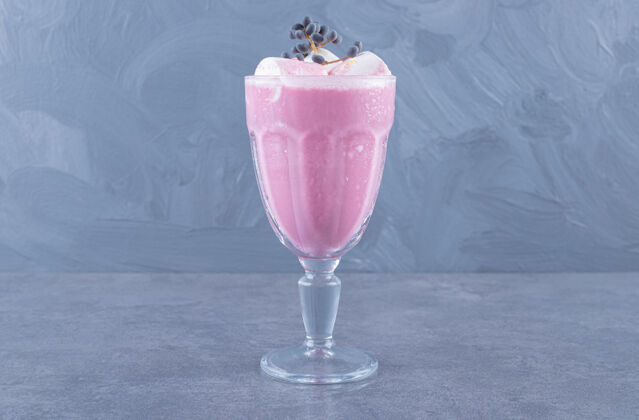 餐桌在灰色背景上拍摄新制作的粉红色奶昔的特写照片水果有机营养