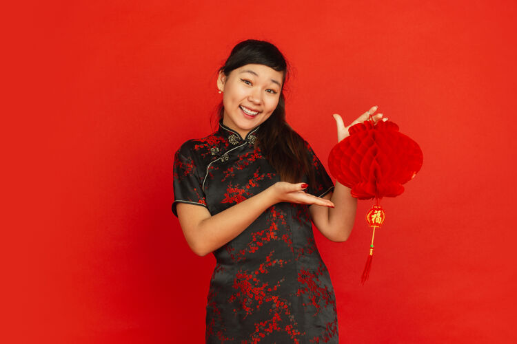 新2020年中国新年快乐红色背景上孤立的亚洲少女肖像穿着传统服装的女模特看起来很快乐 带着装饰微笑庆祝 节日 情感照明手中国