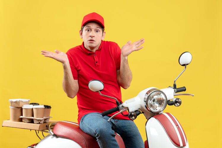 订单顶视图是一个穿着红衬衫 戴着帽子的年轻人在黄色的墙上传递命令运动传送带摩托车