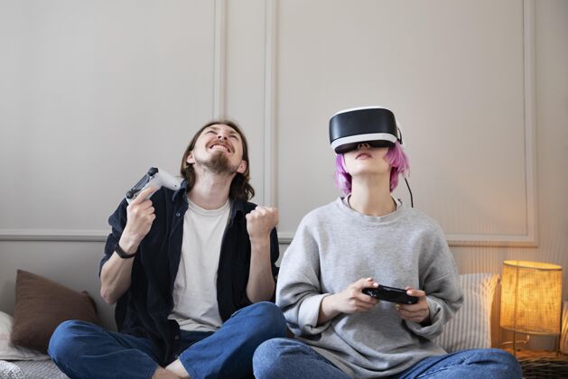 在线一对年轻夫妇在玩虚拟现实游戏玩家室内玩家