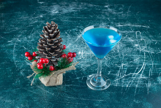 杯子一个大的圣诞松果和一杯蓝色饮料玻璃美味大