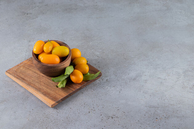 品种新鲜的整个柑橘类金橘水果和叶子放在碗里配料水果小